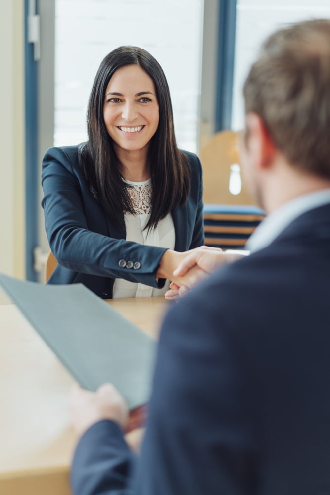 Smiling,woman,job,applicant,shaking,hands,with,a,business,manager