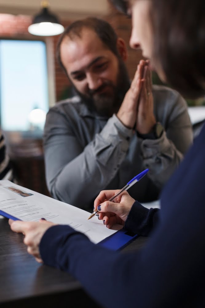 Startup,company,recruiter,reviewing,smiling,job,candidate,cv,while,sitting