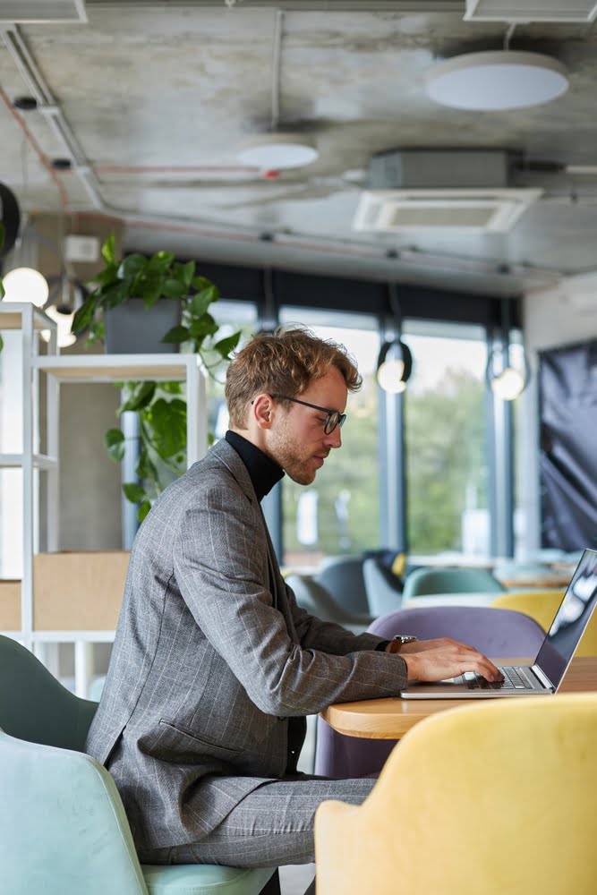 Side,portrait,of,successful,caucasian,young,businessman,,freelancer,sitting,at