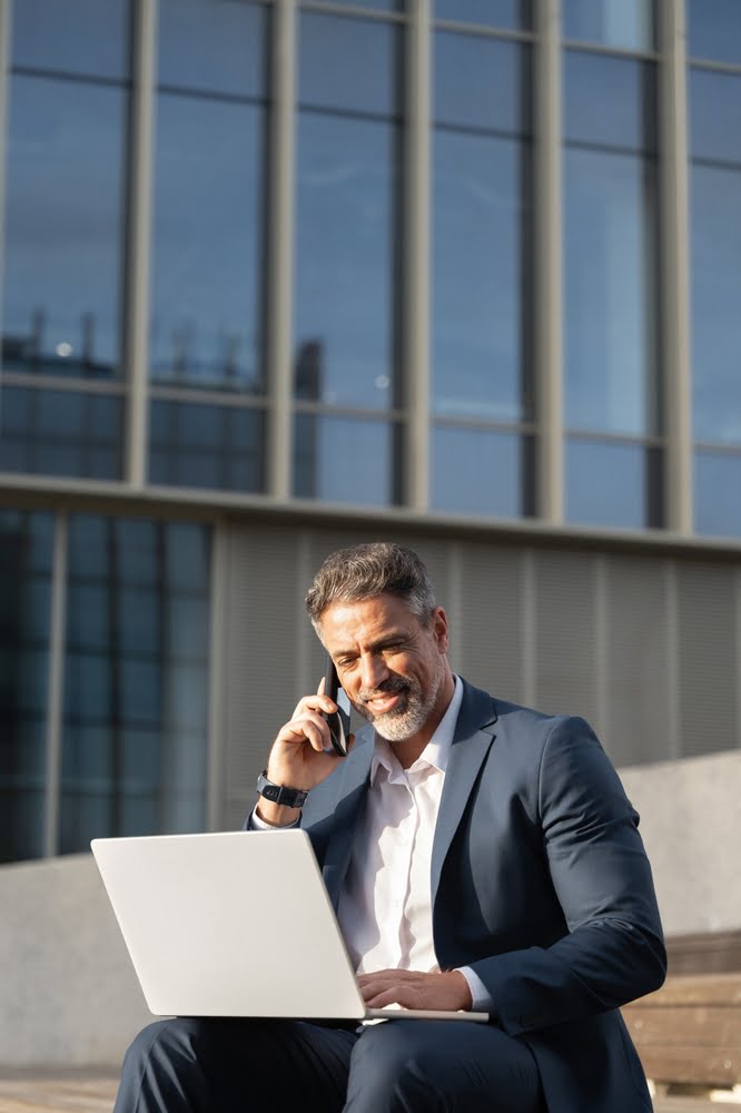 Vertical,portrait,of,mature,businessman,working,remote,on,laptop,,sitting